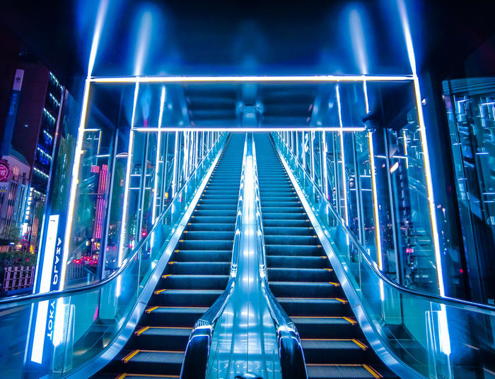 Low angle view of illuminated escalator at night