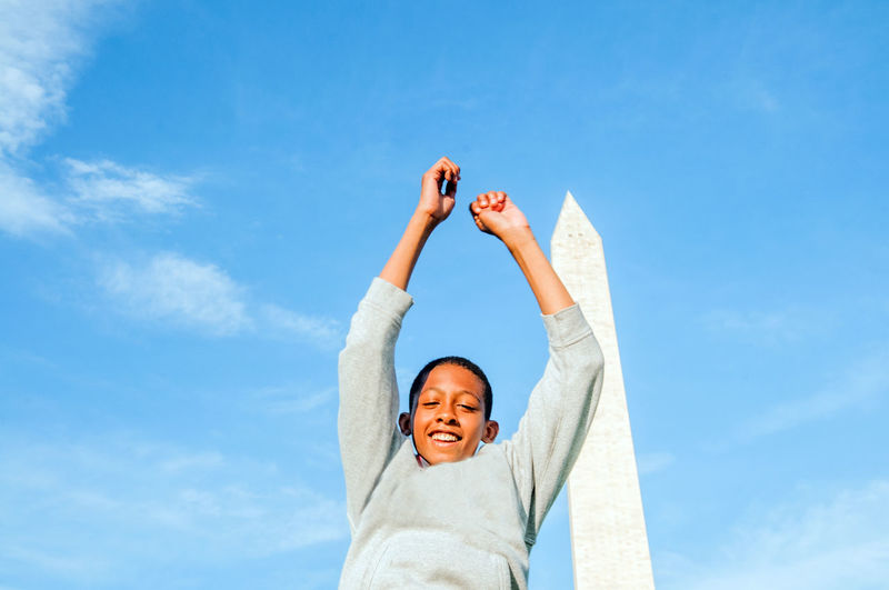 Young afro american male jumping in front of washington monument