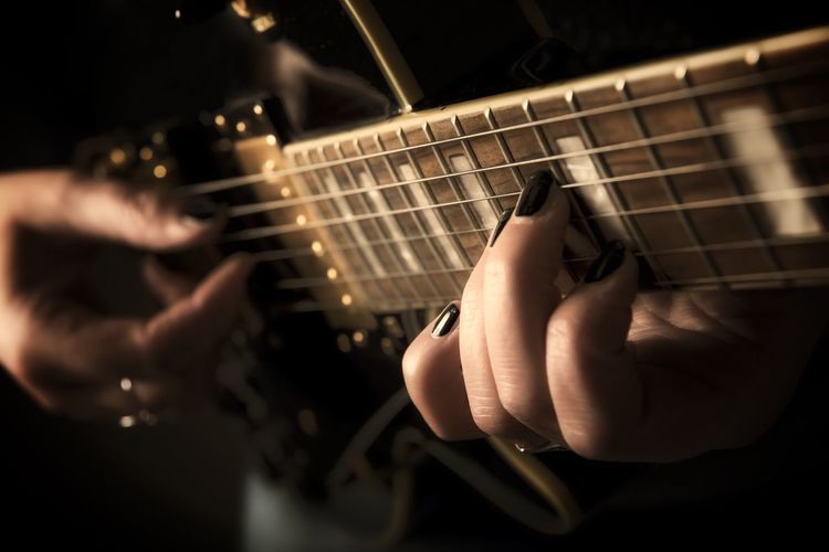 Close-up of hands holding guitar