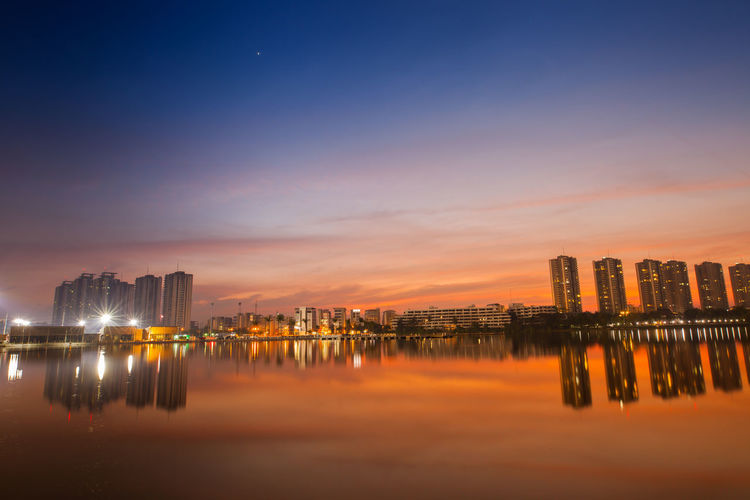 Panoramic view of illuminated buildings against sky during sunset