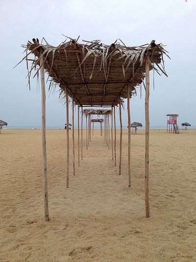 Parasols on beach against clear sky