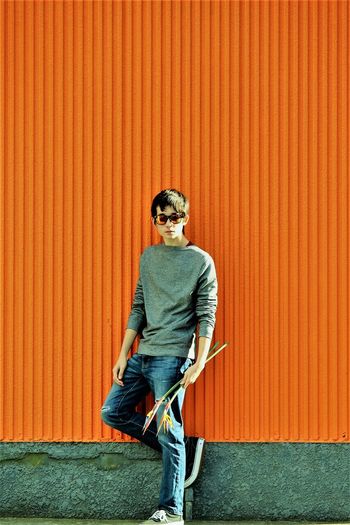Portrait of teenage boy standing against corrugated iron