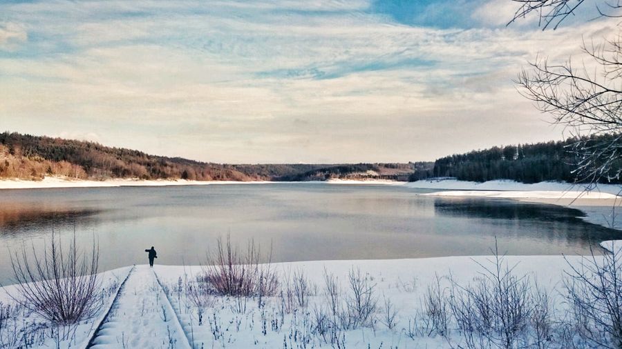 Scenic view of lake against sky during winter
