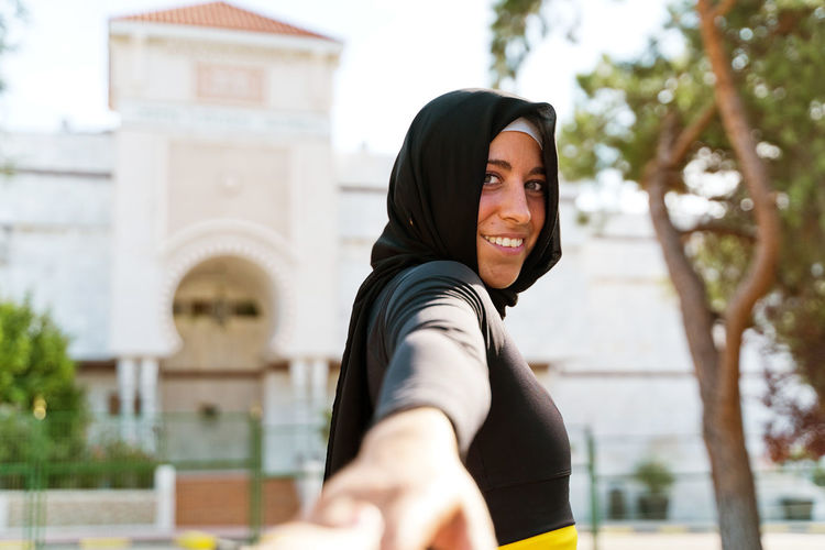 Portrait of a smiling young woman standing outdoors
