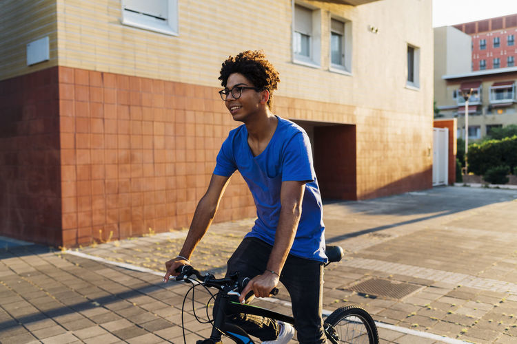 Side view of man riding bicycle on street