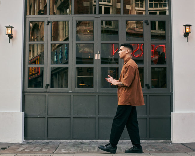 Full length of man standing against building