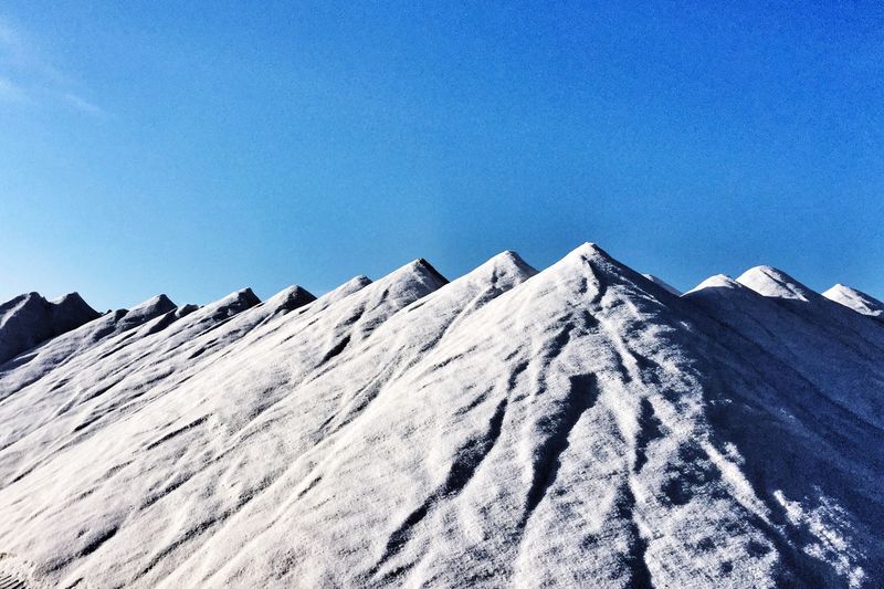 Scenic view of snowcapped mountains against blue sky