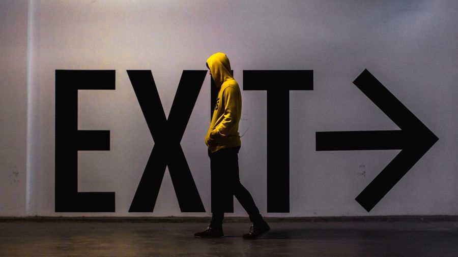 Man walking by exit text