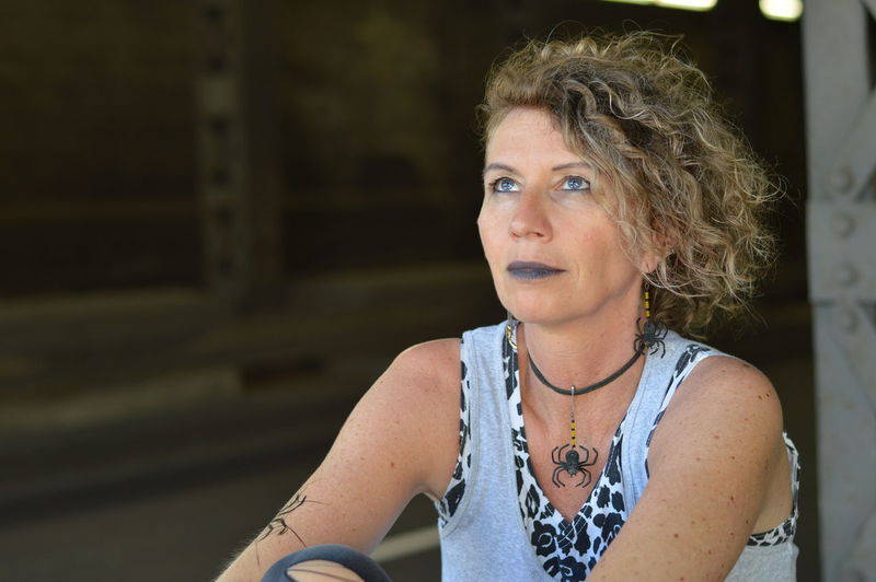 Mature woman looking away while sitting outdoors