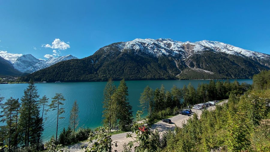 Scenic view of lake achensee, tyrol and mountains with first snow against clear blue sky