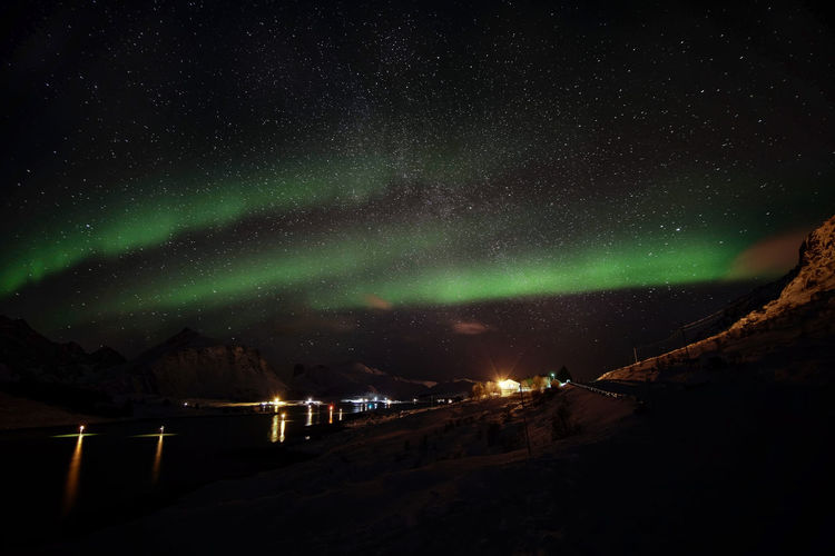 View of aurora borealis over landscape at night