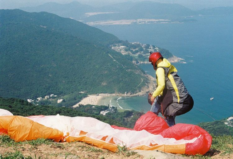 Man with parachute standing on mountain