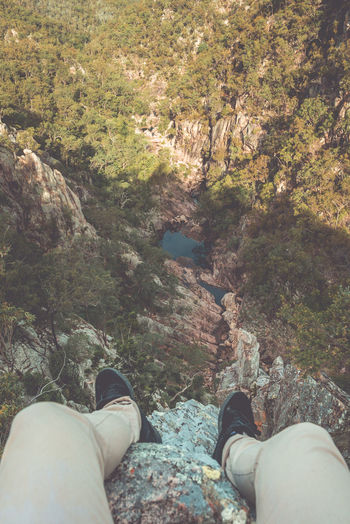 Low section of man relaxing on rock