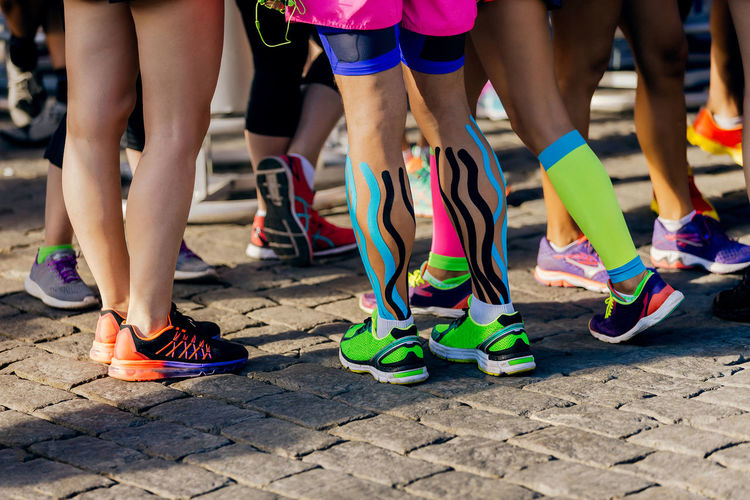 Group female runner legs before marathon race