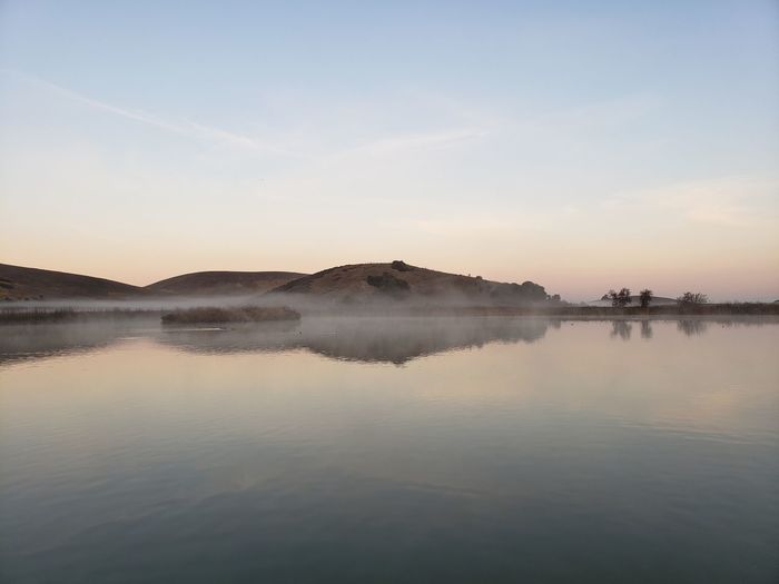 Scenic view of lake against sky during sunset
