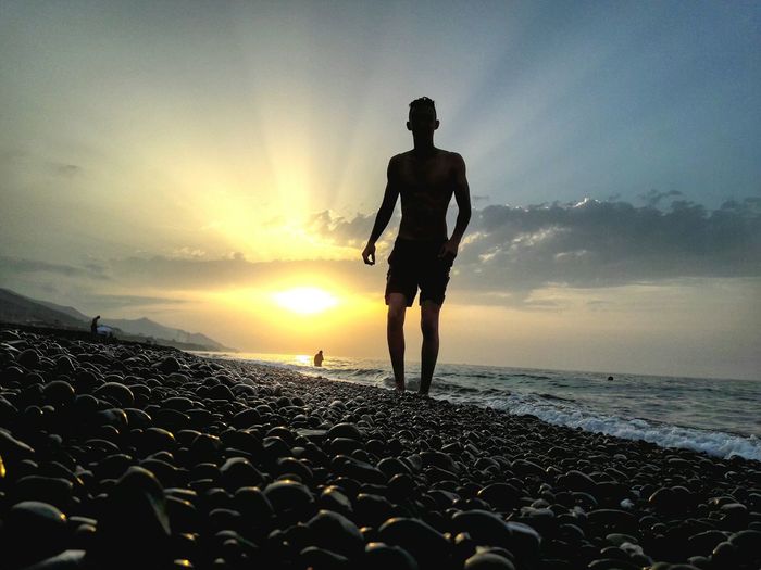 Silhouette of man on beach at sunset