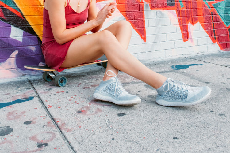 Urban portrait of young woman with skateboard. colorful street art.