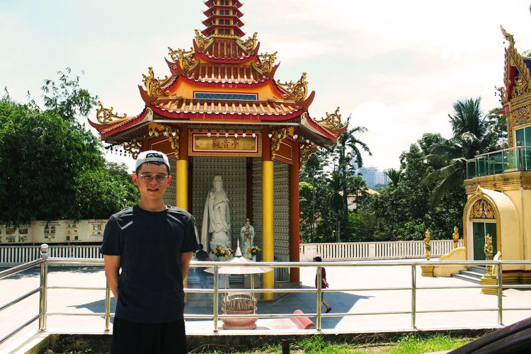 Young man standing outside temple 