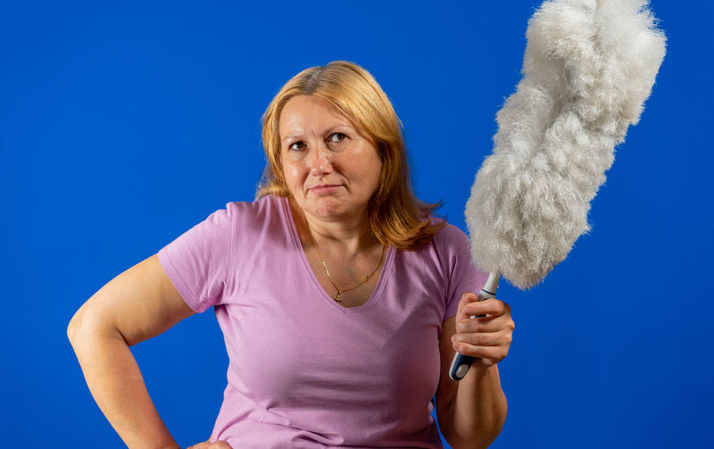 Portrait of woman standing against blue background