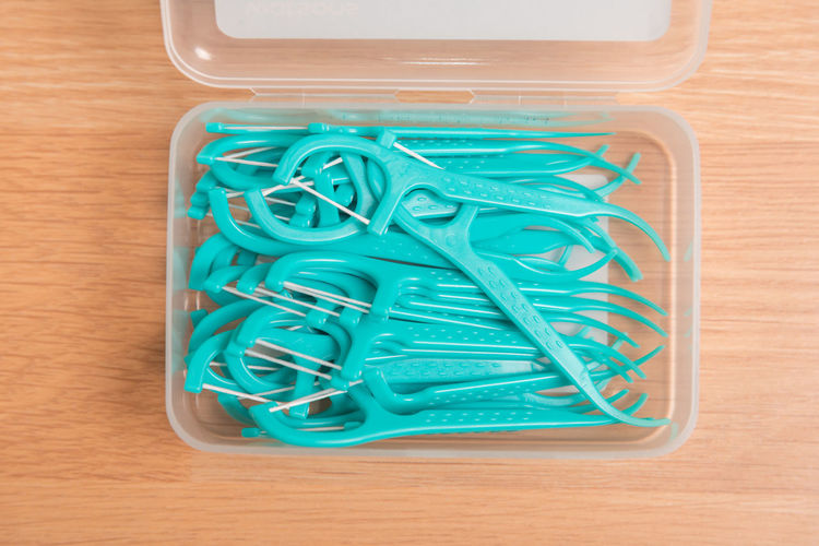 Directly above shot of plastic peelers in box on table