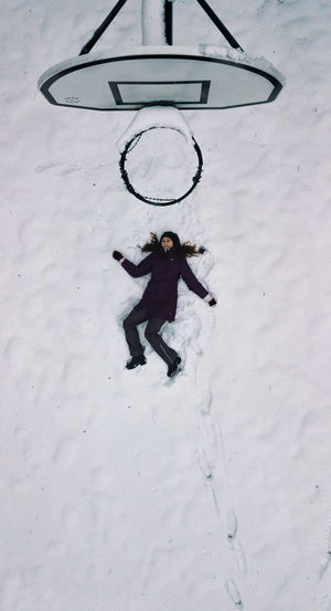 High angle view of child on snow covered field