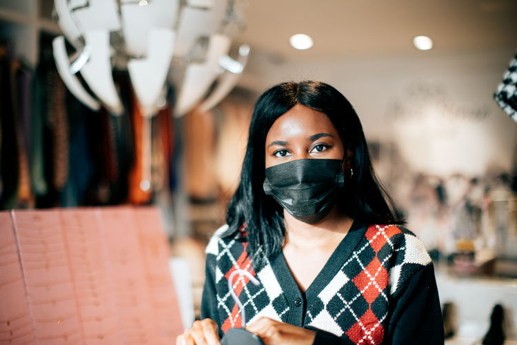 Portrait of a black female shopkeeper at work wearing a protective face mask against viruses