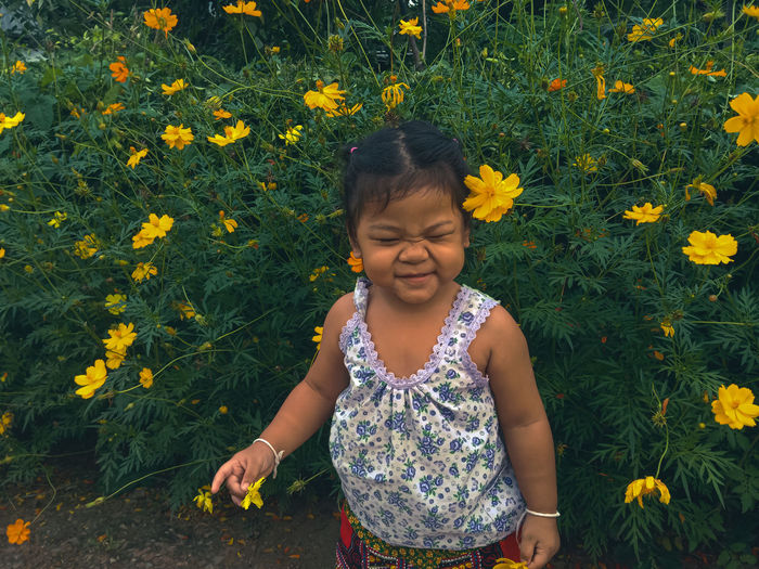 Cute girl with yellow flowers on field