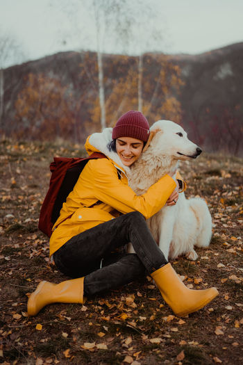 Portrait of woman with dog on field
