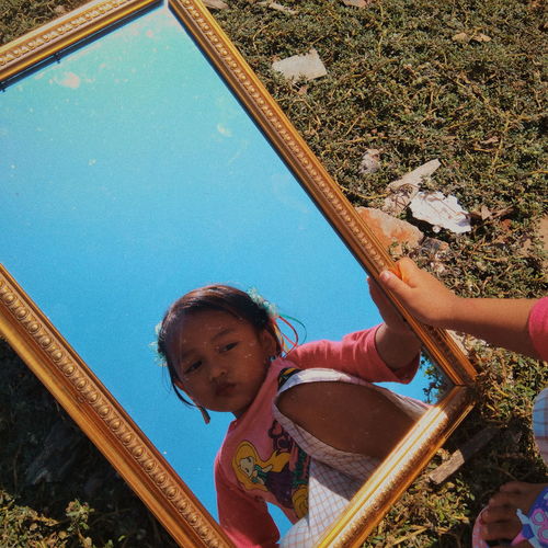Portrait of girl holding mirror