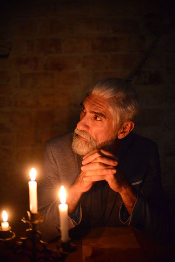 Mid adult man looking at illuminated lamp