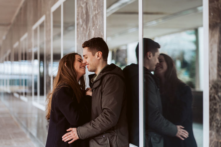 Young couple standing against wall