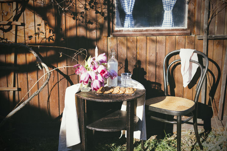 Empty chairs and table by potted plants