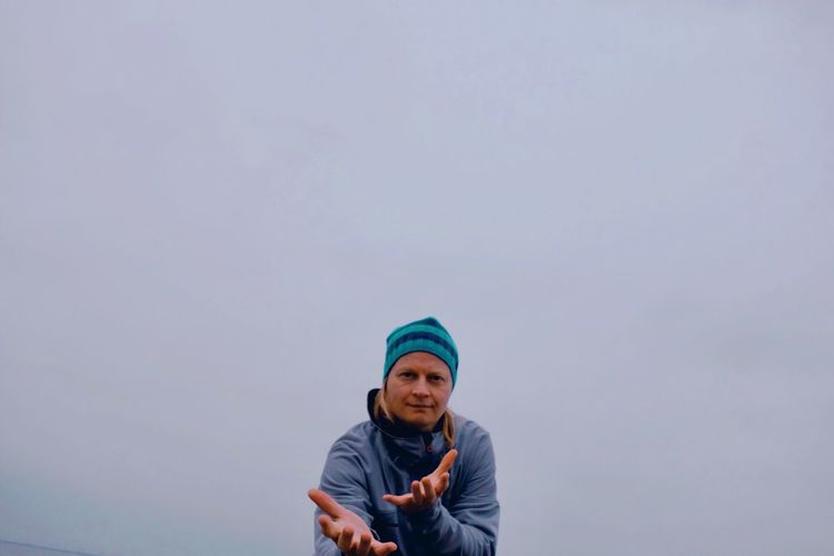 Portrait of man gesturing against sky