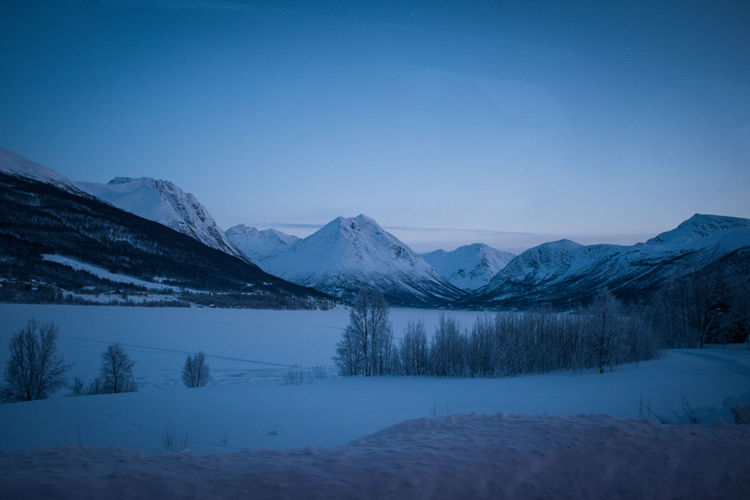 Panoramic view of frozen winter landscape with snow covered mountain range. norway.