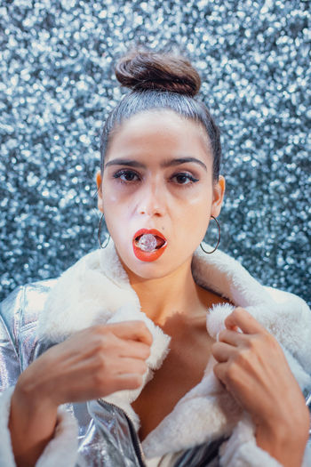 Close-up portrait of young female model with crystal in mouth
