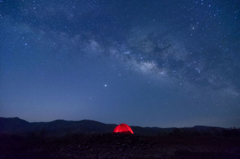 Red tent in reservoir under milky way galaxy with starsbaan sop pat, mae moh lampang thailand.