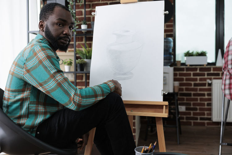 Portrait of artist sitting in studio