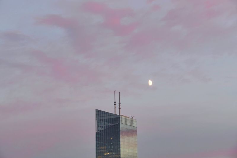 Low angle view of illuminated buildings against sky at sunset
