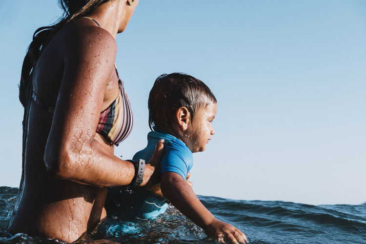 Intimate portrait of mother and baby son at sea