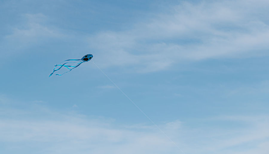 Low angle view of kite flying against blue sky