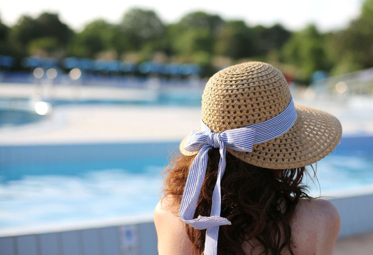 Beautiful woman with straw hat relaxes in the exclusive luxurious resort