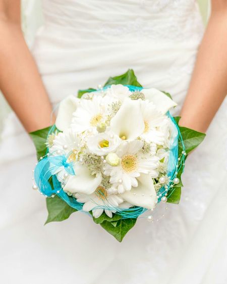 Midsection of bride holding white flower bouquet