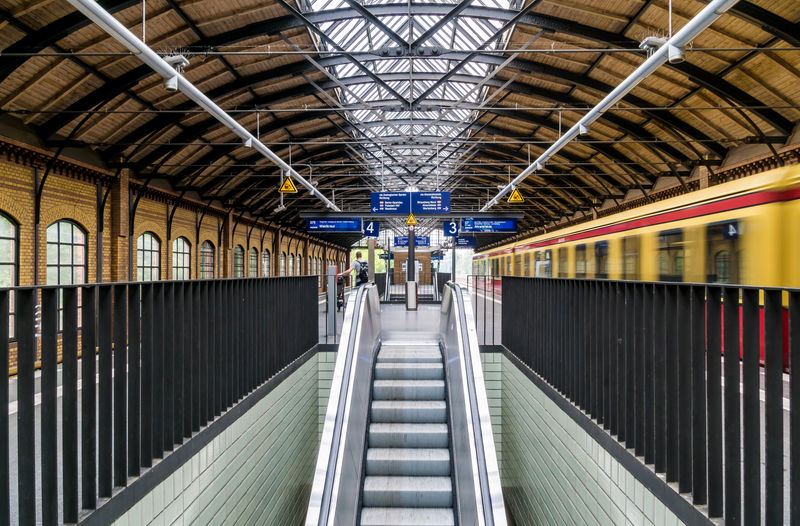 Escalator amidst railings at railroad station