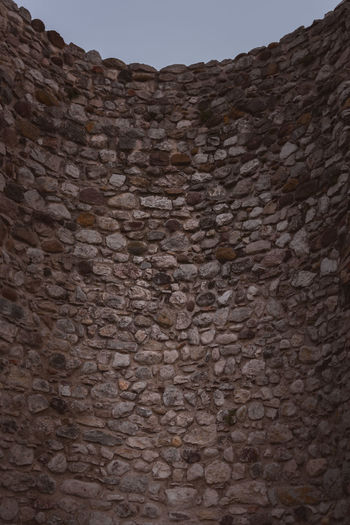 Low angle view of stone wall against sky