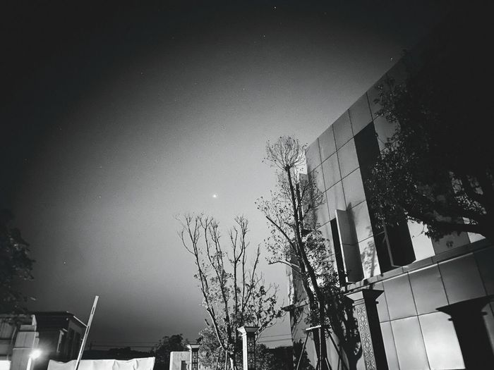Low angle view of buildings against sky at night
