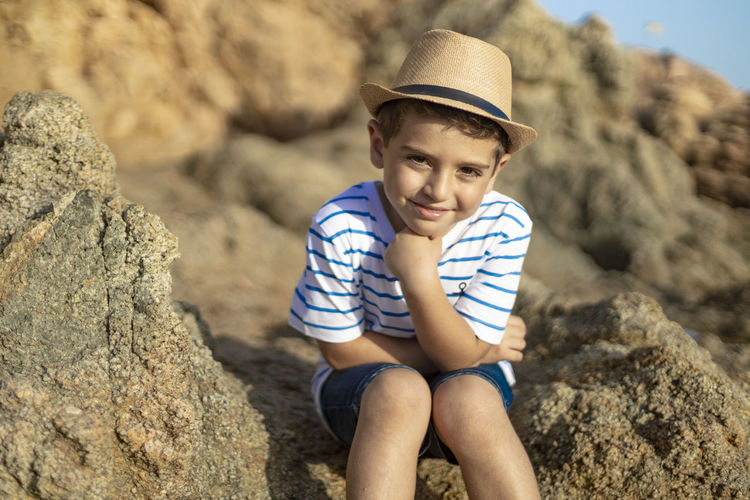 Portrait of boy sitting on rock