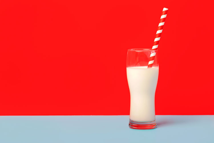 Close-up of drink in glass against red background