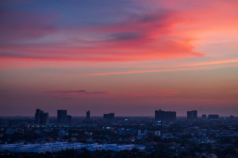 Illuminated buildings against sky during sunset