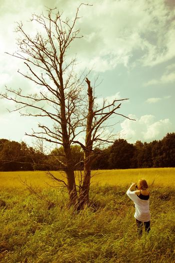 Woman standing on field against sky