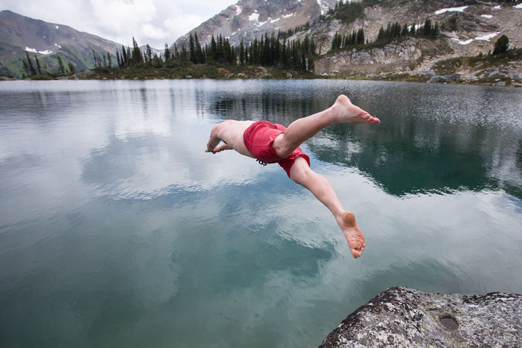 Full length of woman jumping in lake